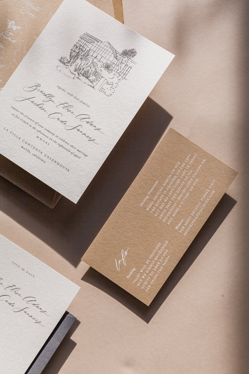 Neutral wedding invitation suite with calligraphy, custom venue illustration, and details card