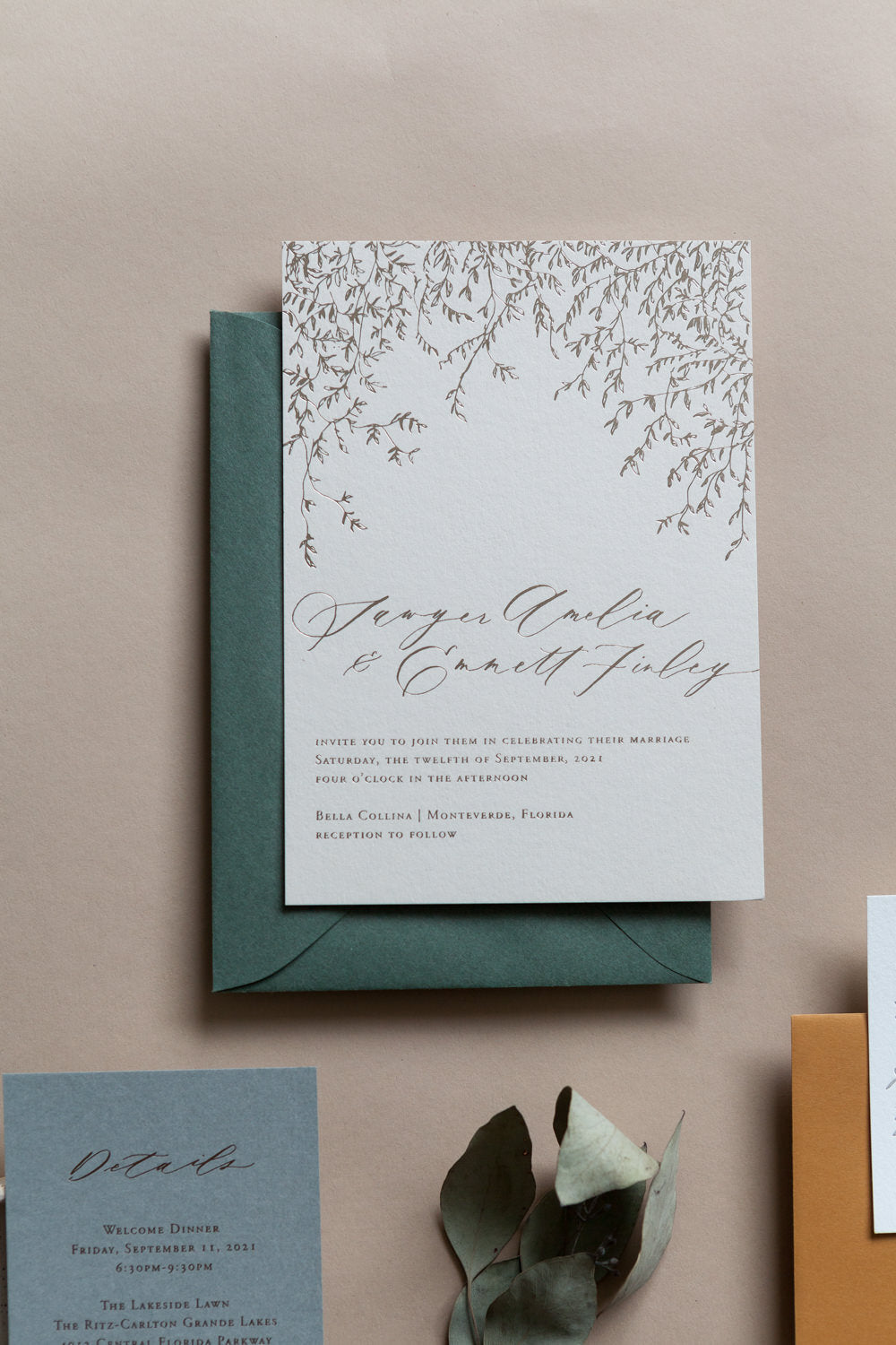 Wedding invitation with cascading vine illustration and calligraphy names on white cardstock with green envelope