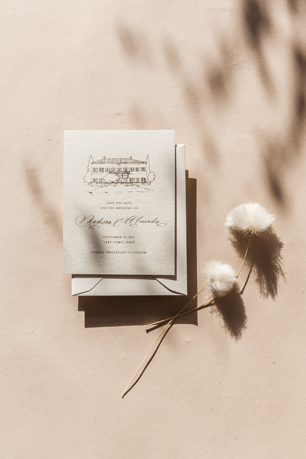 Minimalist save the date card with hand drawn venue illustration and modern calligraphy on neutral wedding stationery