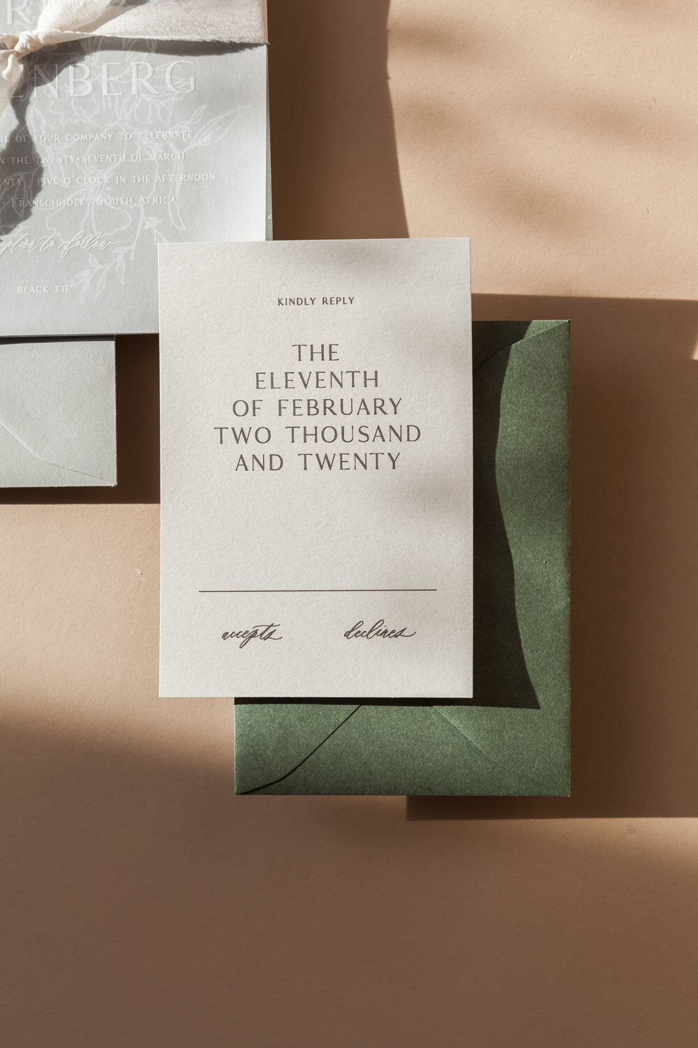 Minimalist wedding RSVP card with modern typography and green envelope, elegant wedding stationery set