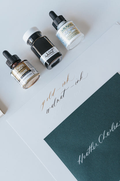 Dr. Ph. Martin's Iridescent, Walnut Drawing Ink, and Pen-White bottles with calligraphy samples on paper