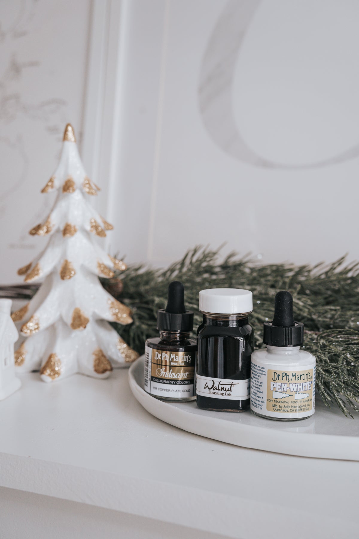 r. Ph. Martin's Iridescent, Walnut Drawing Ink, and Pen-White bottles with holiday decor and greenery