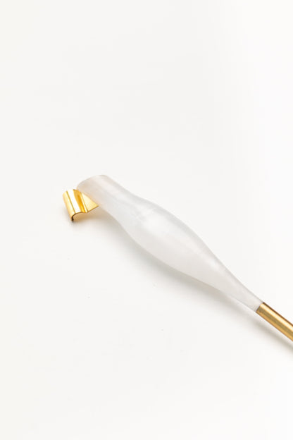 Close-up of a pearl-toned oblique calligraphy pen with a sleek design and a gold brass flange, placed on a white background