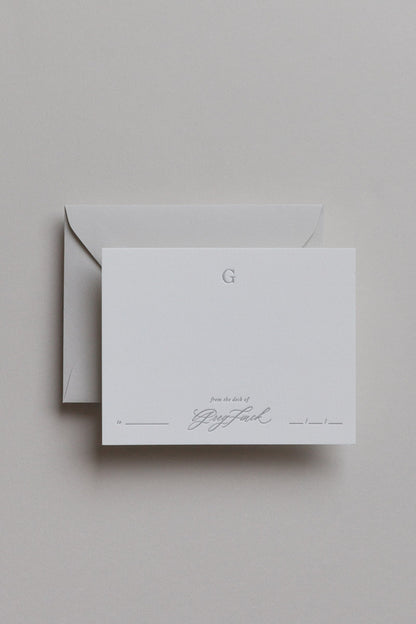 Personalized stationery card with embossed initial and calligraphy name on minimalist neutral background