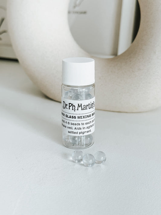 Dr. Ph. Martin's 4mm glass mixing beads in a clear bottle, shown with loose beads, ideal for blending settled pigments