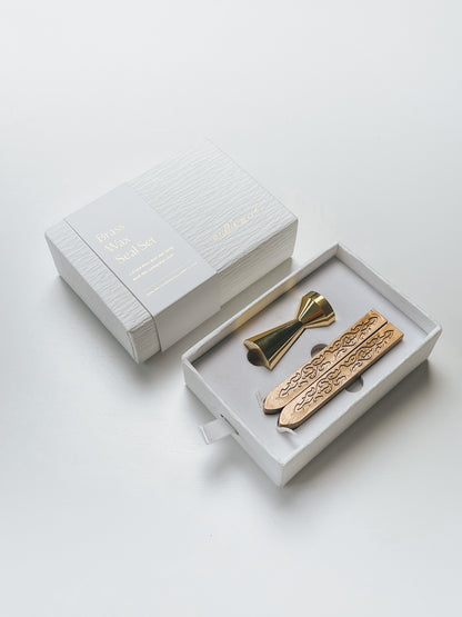 Elegant brass wax seal set with two gold wax sticks in luxury packaging, styled elegantly on a white surface