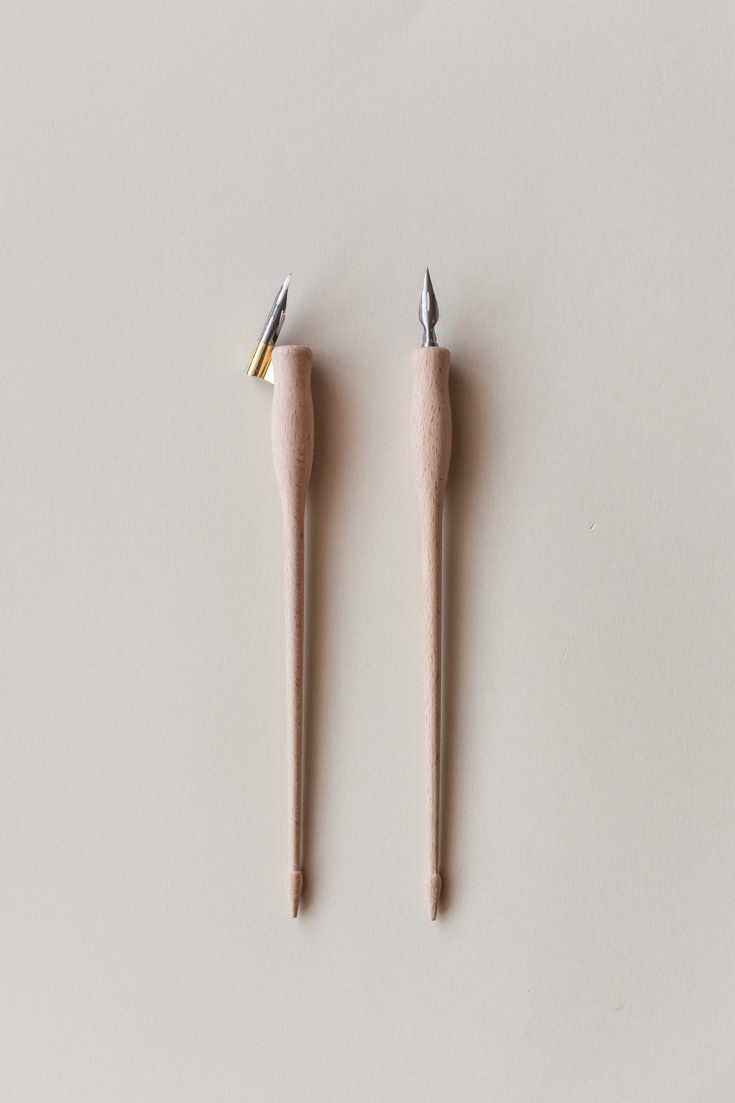 Two dual-purpose calligraphy pens with wooden bodies, shown with straight and oblique brass flanges, ideal for modern calligraphy