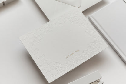 Embossed floral stationery card with gold name personalization on textured white paper