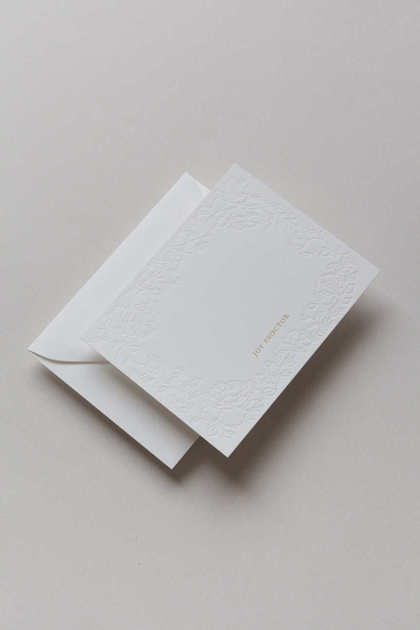 Embossed floral card with gold foil name shown with envelope backing