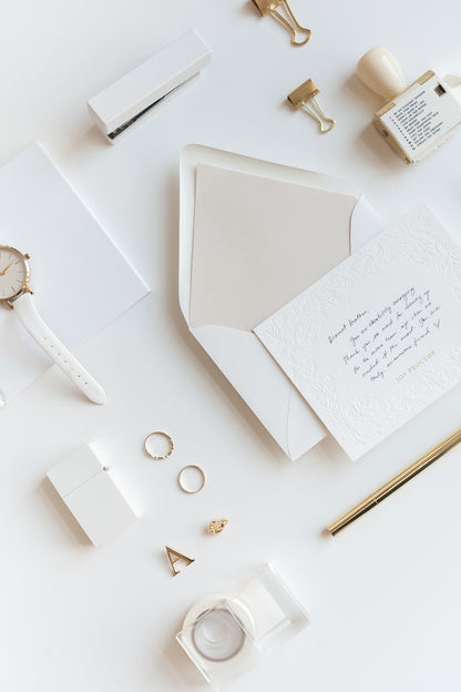 Close-up of embossed floral stationery with handwritten message and gold name detail