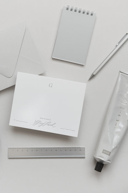 Personalized stationery card with envelope, ruler, pen and notebook in neutral minimalist flat lay