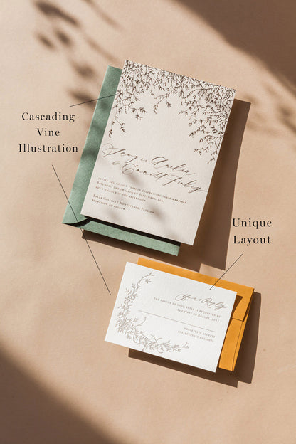 Wedding invitation and RSVP set with botanical vine design and neutral envelopes in warm flat lay